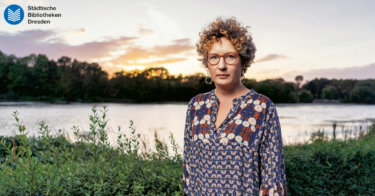 Portrait Rebecca Salentin an einer Mauer stehend.